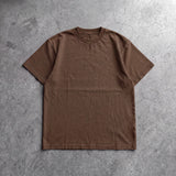 Cotton Collective Chocolate Daily S/S Tee 6.5oz, laid flat on concrete