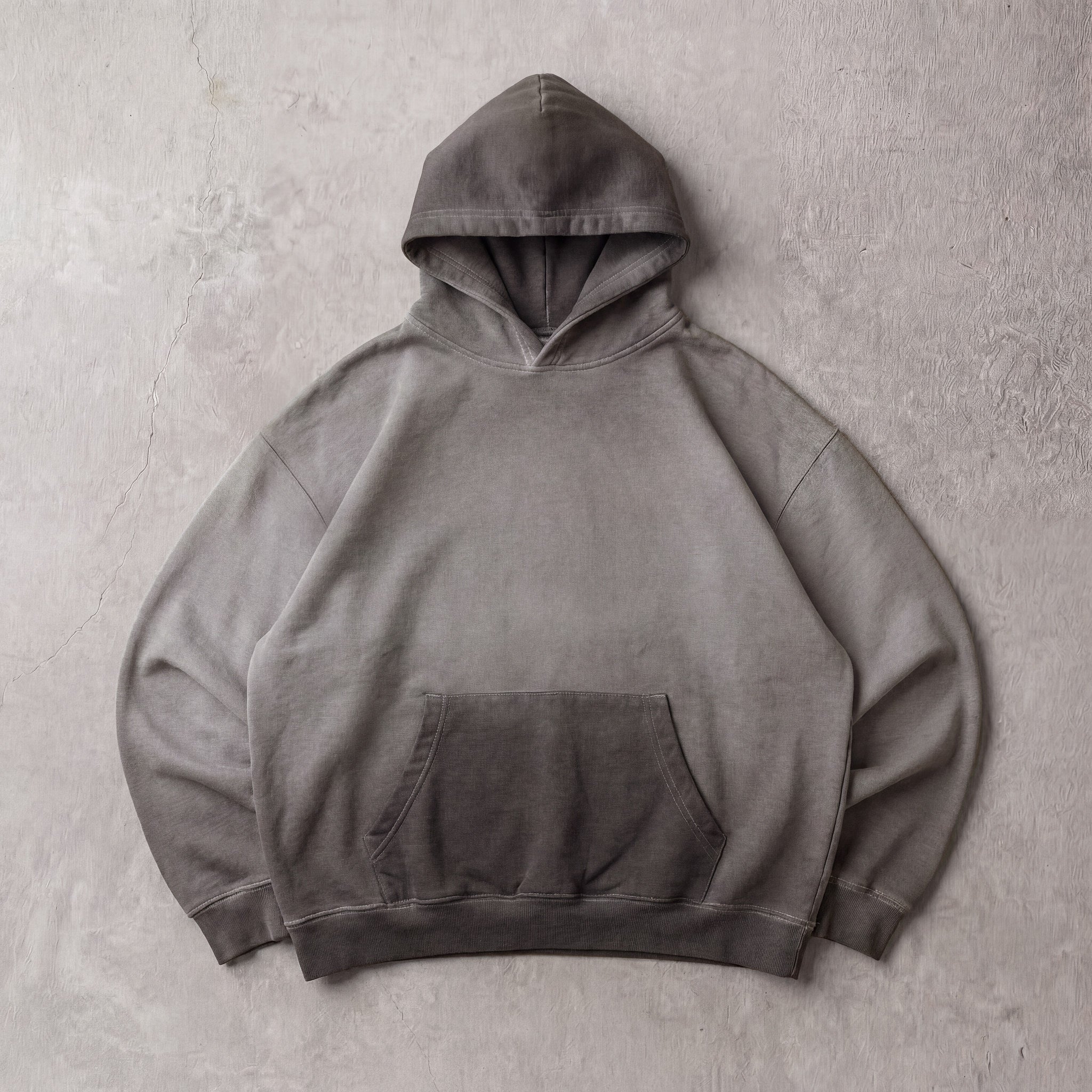 Cotton Collective Charcoal Oil Wash Special Hoodie 14oz, laid flat on concrete
