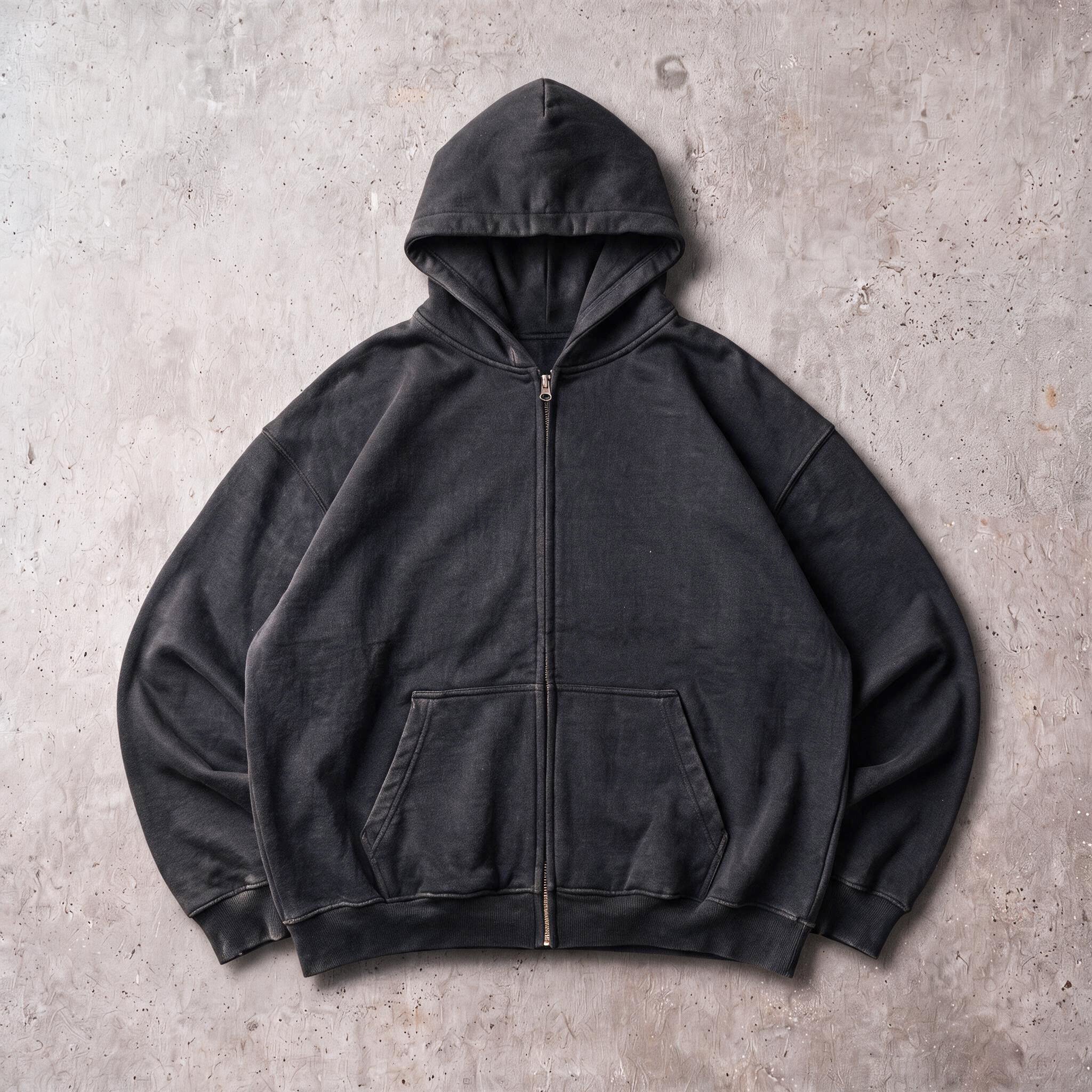 Cotton Collective Vintage Black Special Zip Hoodie 14oz, laid flat on concrete